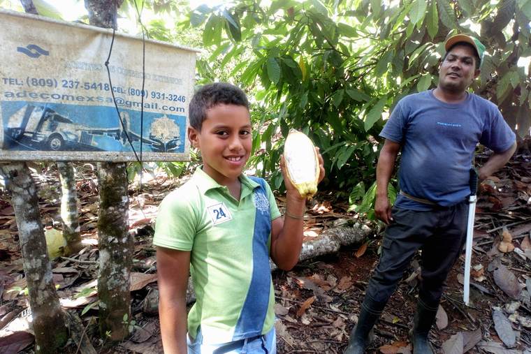 Equipo de AGROSAFRA con una mazorca de cacao en Finca Los Coquitos
